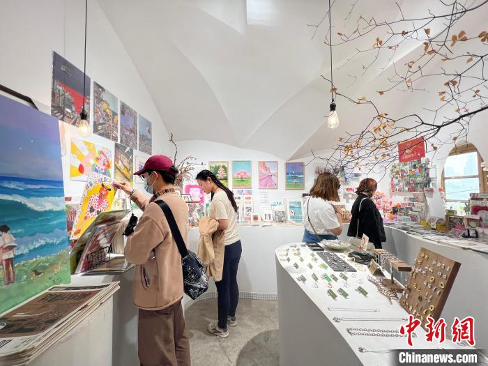 圖為藝術品商店內，顧客挑選插畫作品?！＄婌?攝