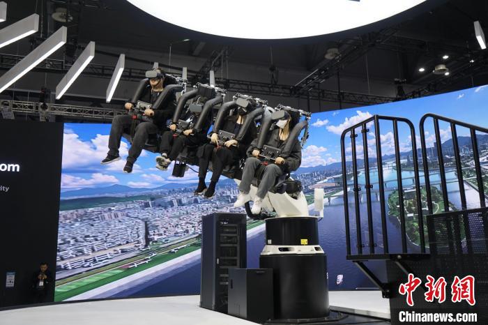 圖為觀眾在展會(huì)模擬體驗(yàn)未來(lái)城市空中移動(dòng)出行方式?！⑿?攝