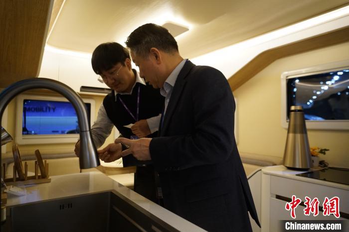 圖為參展商向觀眾介紹房車內(nèi)部設(shè)計(jì)?！⑿?攝