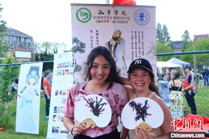 孩子們展示自己的吹墨畫團扇作品。　魯汶孔子學院供圖