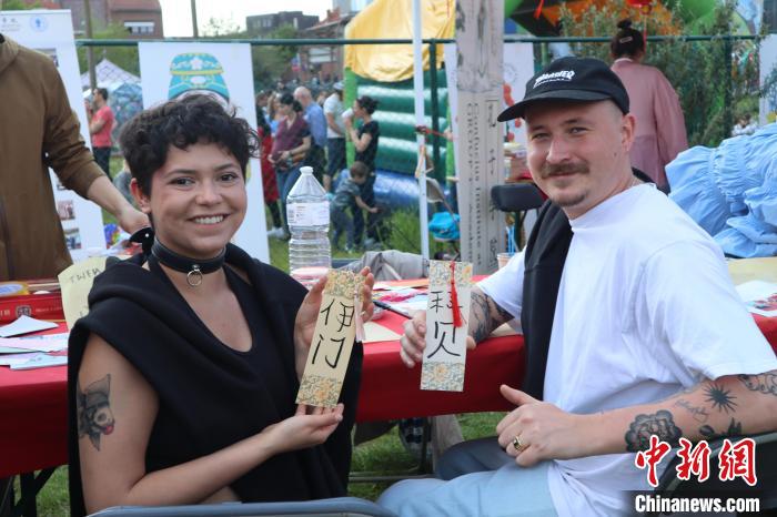 當地民眾在漢字體驗工作坊展示自己手寫的中文名書簽?！◆斻肟鬃訉W院供圖