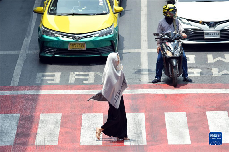 5月17日，行人在泰國曼谷街頭用圍巾遮陽。新華社發(fā)（拉亨攝）