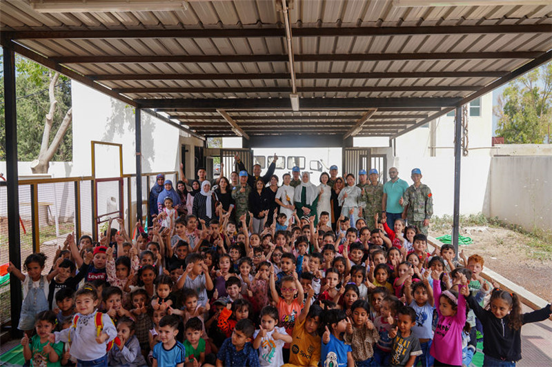 當(dāng)?shù)貢r(shí)間5月30日，黎巴嫩南部庫(kù)雷拉公立小學(xué)，“六一”國(guó)際兒童節(jié)前夕，中國(guó)第21批赴黎維和多功能工兵分隊(duì)官兵看望慰問(wèn)學(xué)校師生，并開(kāi)展文化交流活動(dòng)，圖為我維和官兵同師生合影。李竹林?jǐn)z