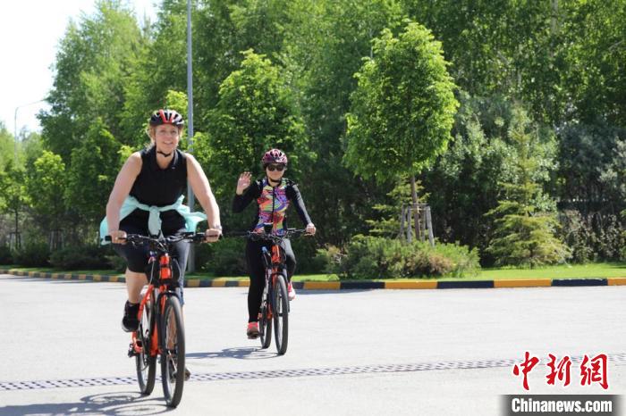 亞信副秘書長遲方(右一)與聯(lián)合國駐哈協(xié)調員在騎行活動中?！喰琶貢幑﹫D