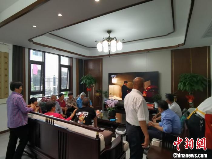 親友們集中在費(fèi)俊龍家中觀看返程的視頻?！＄娚?攝