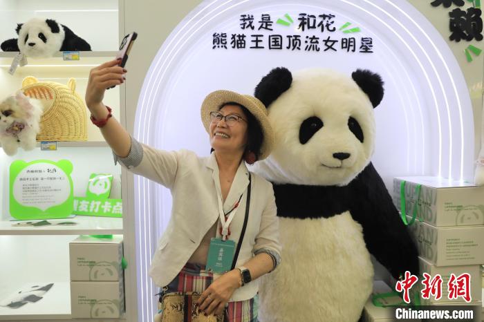 美國(guó)華視總裁楊蓮花與大熊貓文創(chuàng)產(chǎn)品合影?！⊥趵?攝