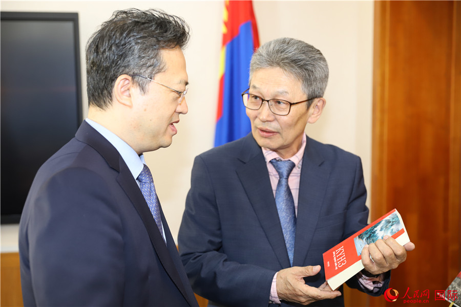 其米德策耶（右一）向李峙介紹翻譯成果。人民網(wǎng)記者 霍文攝