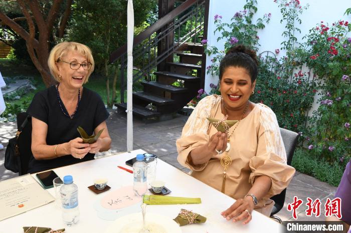 圖為嘉賓展示包粽子成果?！“亓种袊幕行墓﹫D。