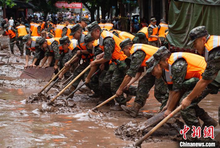7月4日，萬(wàn)州區(qū)五橋街道，武警官兵清理街道上的淤泥?！∪矫宪?攝