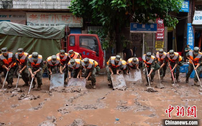 7月4日，萬(wàn)州區(qū)五橋街道，武警官兵清理街道上的淤泥?！∪矫宪?攝