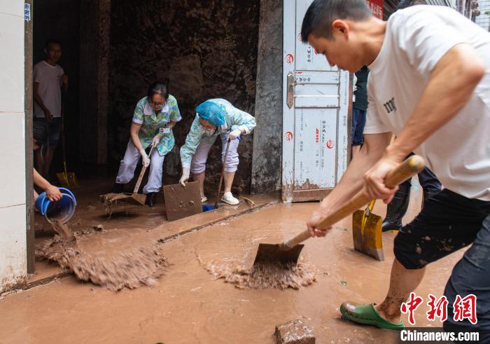 7月4日，萬(wàn)州區(qū)五橋街道，洪水退去后，居民開(kāi)展清淤工作。　冉孟軍 攝