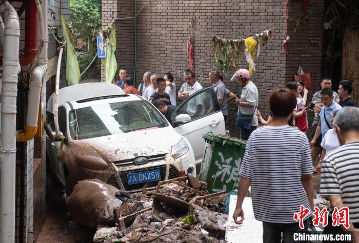 7月4日，萬(wàn)州區(qū)五橋街道，居民救援受困的私家車(chē)?！∪矫宪?攝
