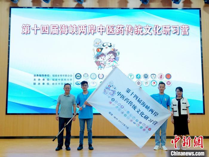 共青團(tuán)福建省委副書記吳雪(右一)、福建中醫(yī)藥大學(xué)黨委副書記林羽(左一)為兩岸學(xué)生代表頒授營(yíng)旗?！≡S燁婷 攝