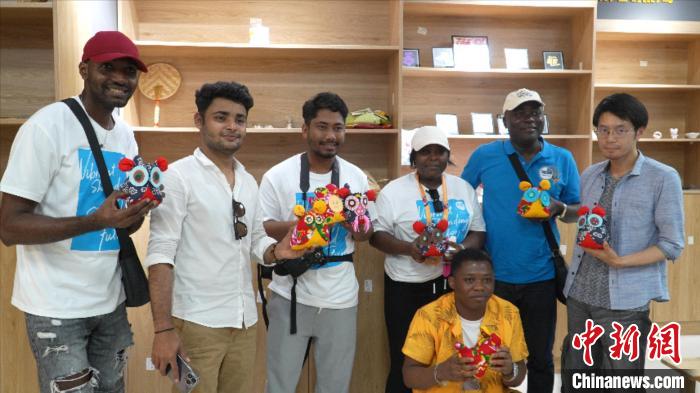 圖為國(guó)際青年代表展示親手制作的東營(yíng)非遺黃河口布偶 ?！↓R魯 攝