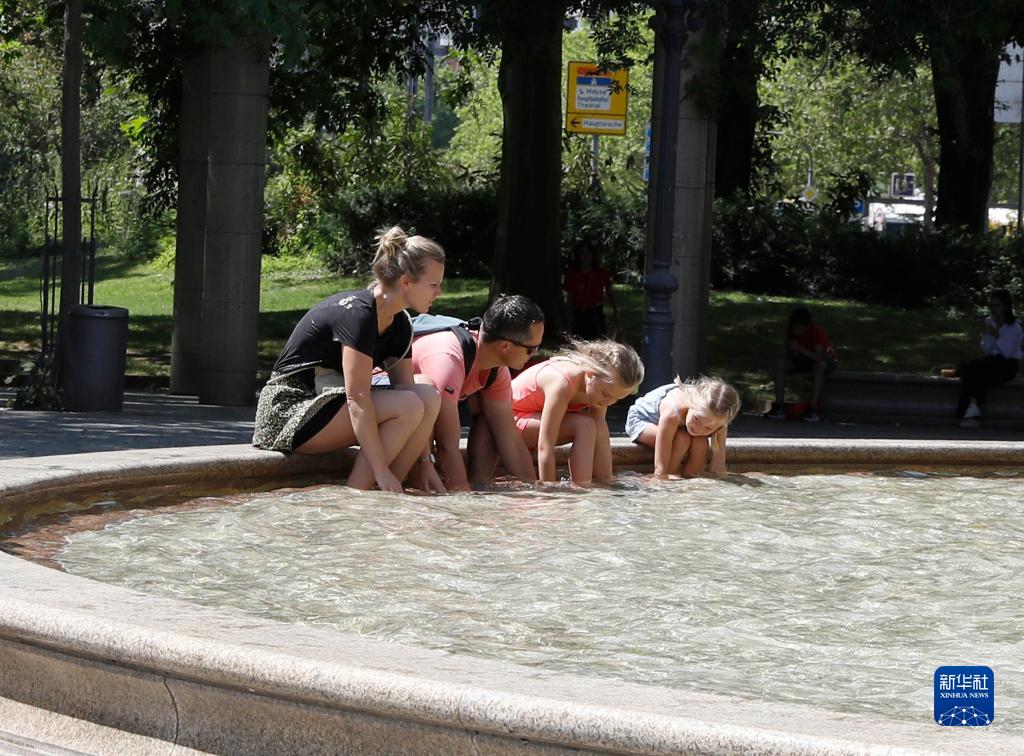 7月8日，人們?cè)诘聡?guó)法蘭克福的一處噴泉玩水。近日，德國(guó)法蘭克福逐漸迎來(lái)暑熱天氣。新華社記者 張帆 攝