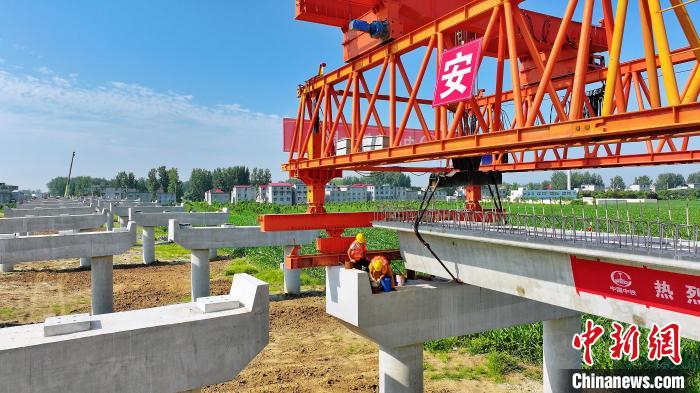 長25米重80噸的箱梁平穩(wěn)、精準地落在S314分離式立交橋25號和26號墩上?！⒂癫?攝