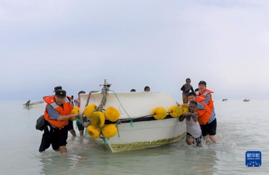 7月21日，中國海軍“和平方舟”號醫(yī)院船醫(yī)護人員涉水登島，前往基里巴斯一診療點。新華社記者 黎云 攝