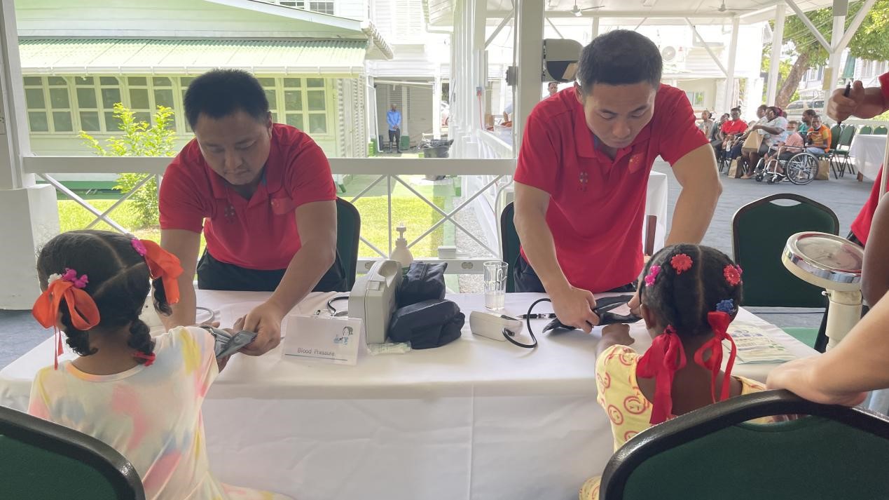 醫(yī)療隊(duì)員為福利院兒童進(jìn)行檢查。第18期援圭亞那醫(yī)療隊(duì)供圖