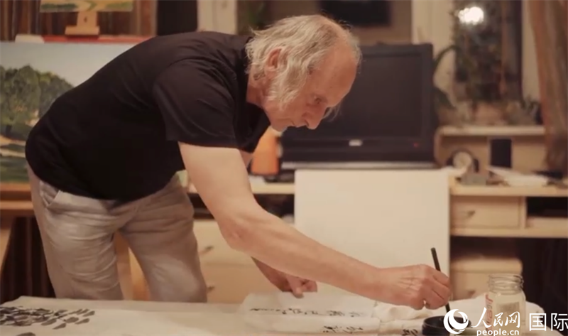 伊戈爾·布爾東諾夫在畫作上題詞。人民網(wǎng)記者 馬天翼攝