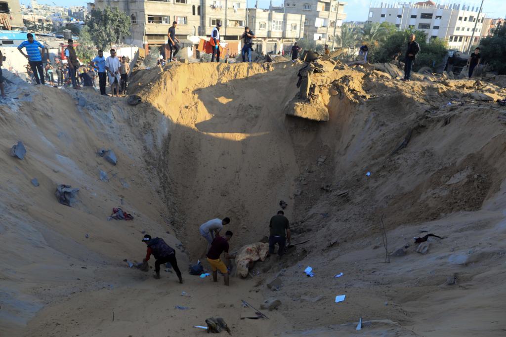 10月16日，在加沙地帶南部城市汗尤尼斯，人們?cè)谠庖陨幸u擊后的建筑廢墟中救援傷者。 新華社發(fā)（亞西爾·庫(kù)迪 攝）
