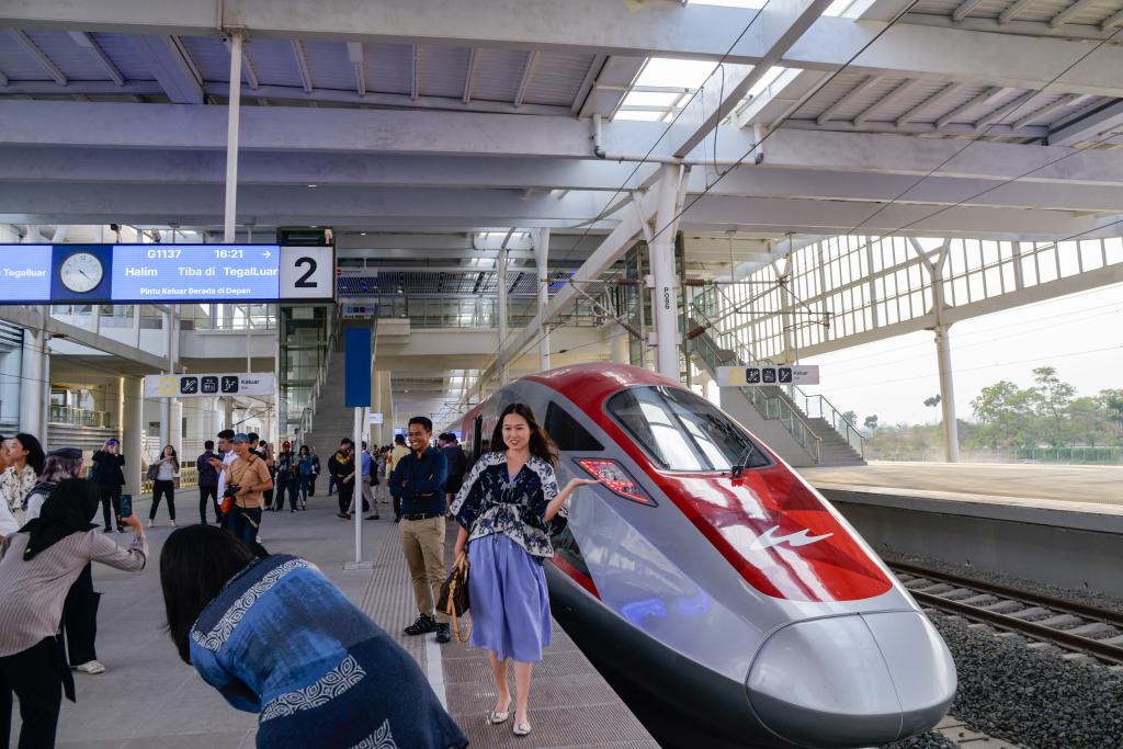 10月17日，在印度尼西亞萬隆德卡魯爾站，乘客在站臺上和雅萬高鐵高速動車組列車合影。
