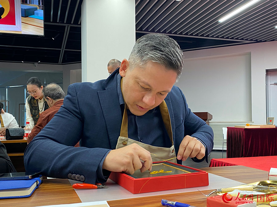 2023“一帶一路”媒體合作論壇聯(lián)合采訪團(tuán)團(tuán)員，親身體驗(yàn)景泰藍(lán)工藝。人民網(wǎng)記者 于洋攝