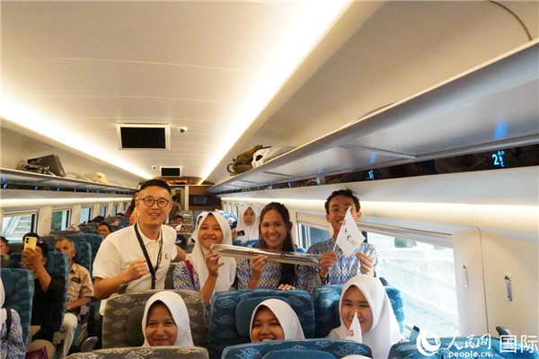 第一次乘坐雅萬高鐵動車組的學(xué)生們與動車組模型合影。人民網(wǎng)記者曹師韻攝