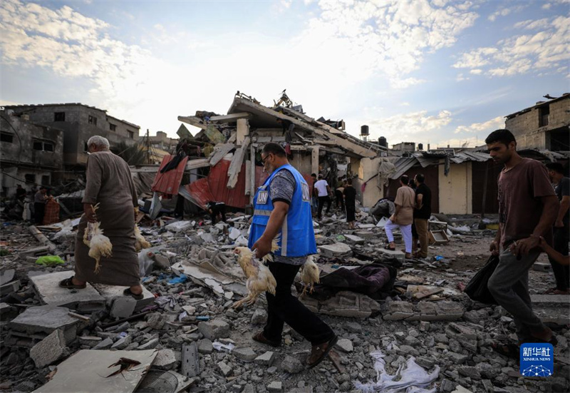 10月27日，在加沙地帶南部城市汗尤尼斯，人們經(jīng)過(guò)以軍襲擊后的房屋廢墟。
