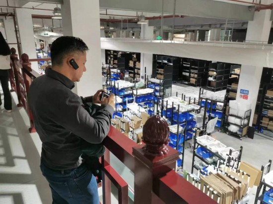 2023“一帶一路”媒體合作論壇聯(lián)合采訪團(tuán)團(tuán)員在仁和醫(yī)藥物流園拍攝記錄轉(zhuǎn)運(yùn)流程。（本報(bào)記者 黃超攝）