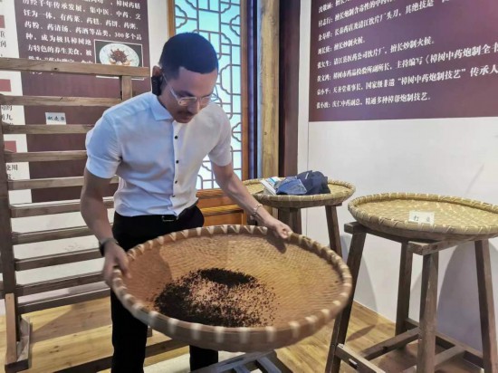 2023“一帶一路”媒體合作論壇聯(lián)合采訪團(tuán)團(tuán)員在非遺文化展示館體驗(yàn)中藥炮制技藝。（本報(bào)記者 黃超攝）