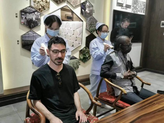 2023“一帶一路”媒體合作論壇聯(lián)合采訪團(tuán)團(tuán)員在九牛草展示館體驗(yàn)艾灸。（本報(bào)記者 黃超攝）
