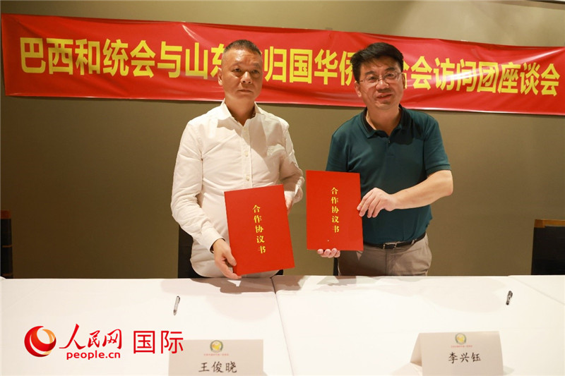 中國僑聯(lián)副主席、山東省僑聯(lián)主席李興鈺（右）與巴西和統(tǒng)會(huì)會(huì)長王俊曉簽署合作協(xié)議書。人民網(wǎng)記者 陳海琪攝