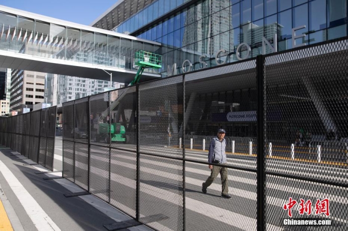當(dāng)?shù)貢r間11月10日，一名行人從美國舊金山莫斯康中心周圍的金屬圍欄旁經(jīng)過。隨著亞太經(jīng)合組織(APEC)第三十次領(lǐng)導(dǎo)人非正式會議臨近，作為會議場地的莫斯康中心附近出現(xiàn)金屬圍欄，執(zhí)勤警察也大幅增加。<a target='_blank' href='/'><p  align=