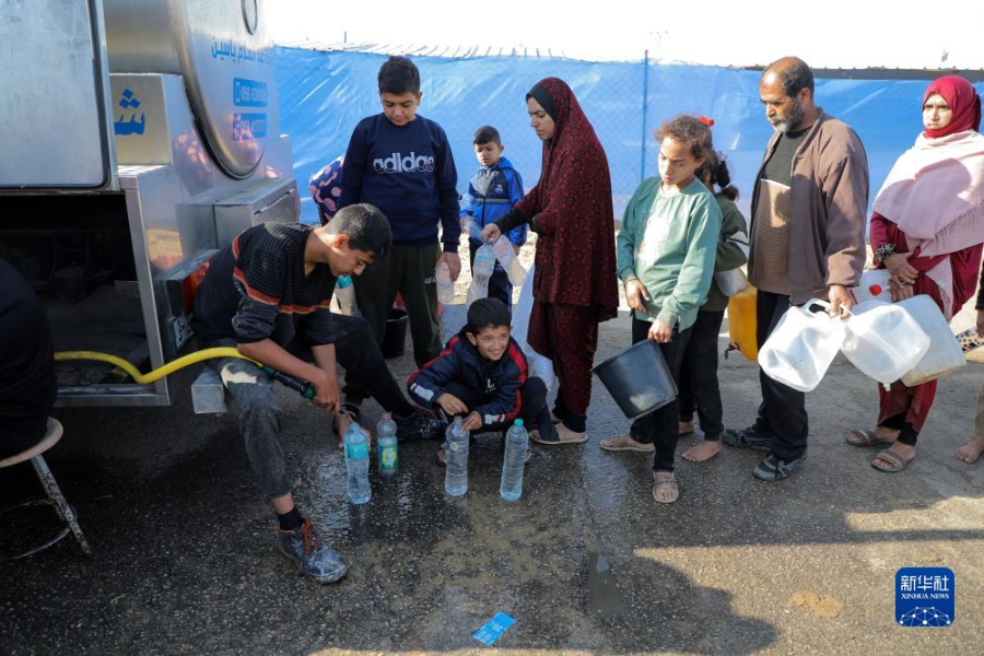 12月8日，在加沙地帶南部城市拉法一處臨時(shí)營(yíng)地內(nèi)，人們排隊(duì)打水。新華社發(fā)（里澤克·阿卜杜勒賈瓦德 攝）