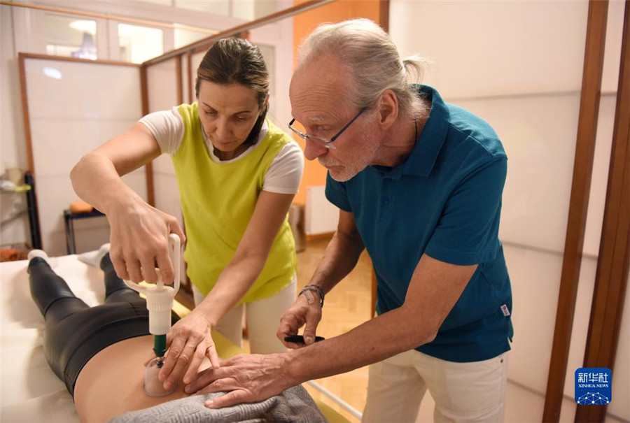 12月12日，在奧地利維也納，科格勒醫(yī)生（右）和助手在為病人進(jìn)行拔罐治療。新華社記者 賀燦鈴 攝