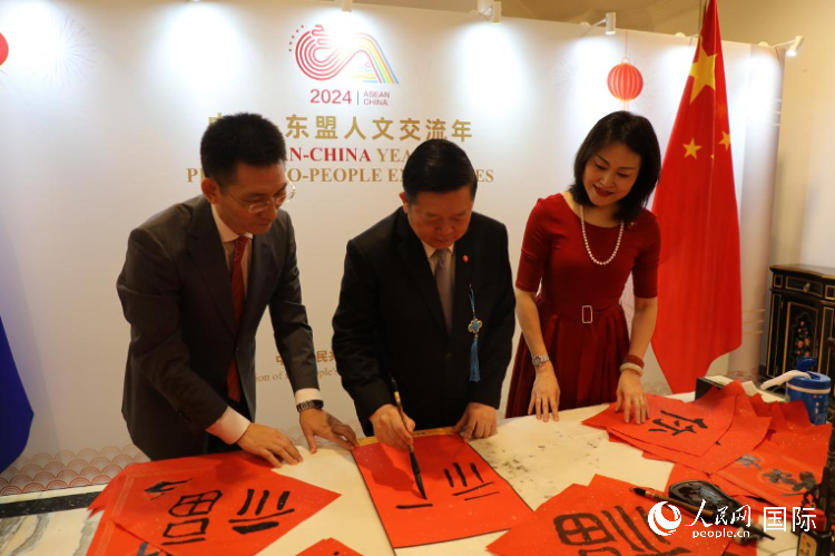 東盟秘書長高金洪（中）在活動現(xiàn)場寫福字。人民網(wǎng)記者曹師韻攝