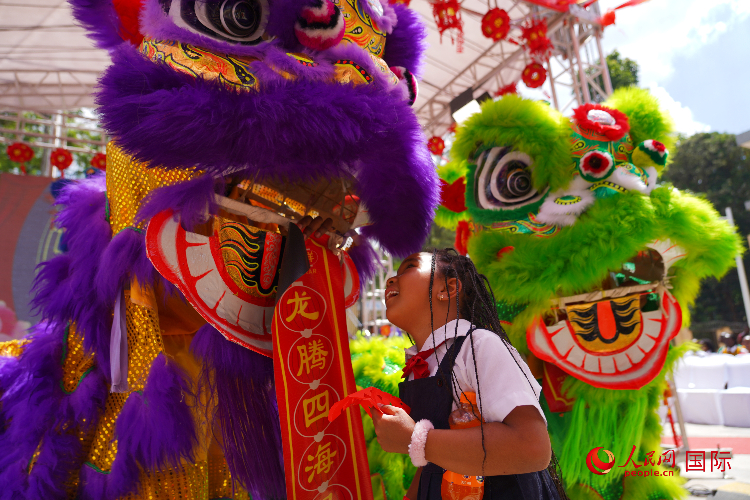 小朋友與舞獅表演者互動。人民網(wǎng)記者 黃煒鑫攝