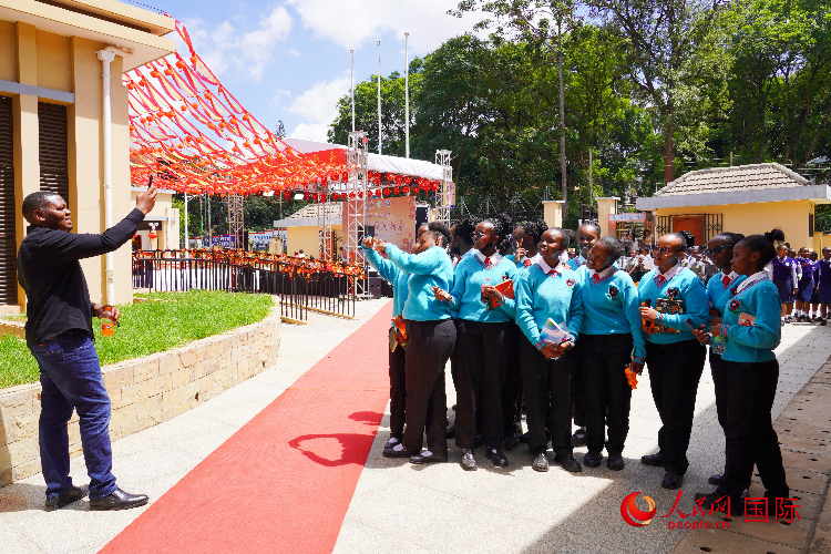 一名老師在給學(xué)生拍照留念。人民網(wǎng)記者 黃煒鑫攝