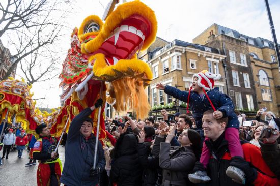 2月11日，人們?cè)谟?guó)倫敦的新春巡游活動(dòng)中觀看舞龍表演。新華社發(fā)（史蒂芬·程攝）