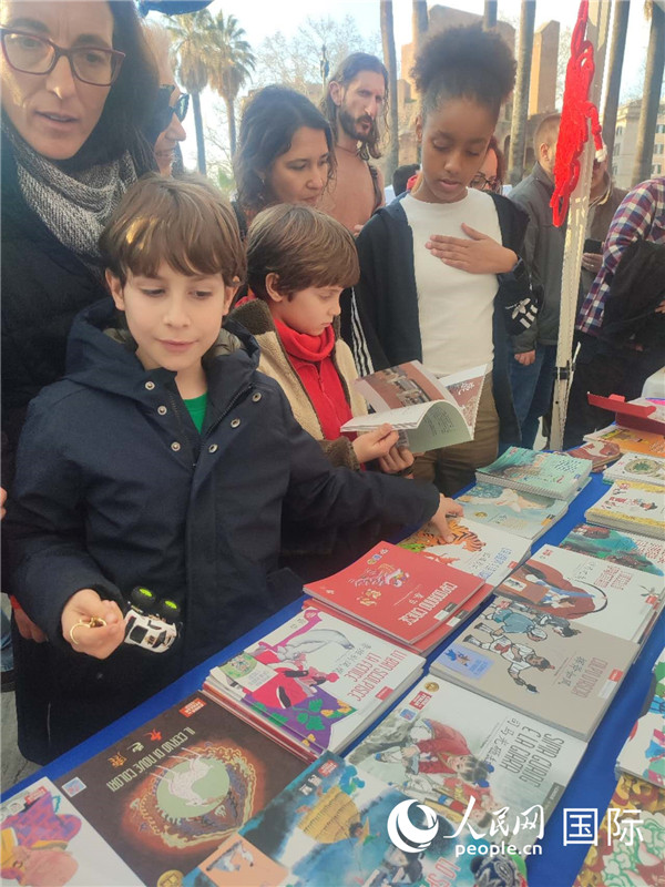 印刷精美的中國(guó)傳統(tǒng)文化叢書(shū)吸引了小游客的注意。人民網(wǎng)記者鄭彬攝