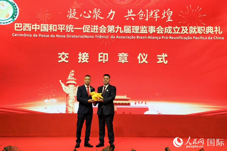 就職典禮中，巴西和統(tǒng)會第七屆和第八屆會長王俊曉與新任會長張小春交接印章。人民網(wǎng)記者 時元皓攝