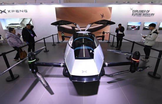 2023年12月1日，在鏈博會智能汽車鏈展區(qū)小鵬汽車展臺，參觀者觀看一臺智能飛行器。新華社記者蔡湘鑫攝