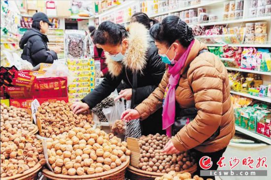 　　在長沙南門口菜市場附近的一家炒貨店內(nèi)，市民正在選購年貨?！　￠L沙晚報全媒體記者 范宏歡 攝