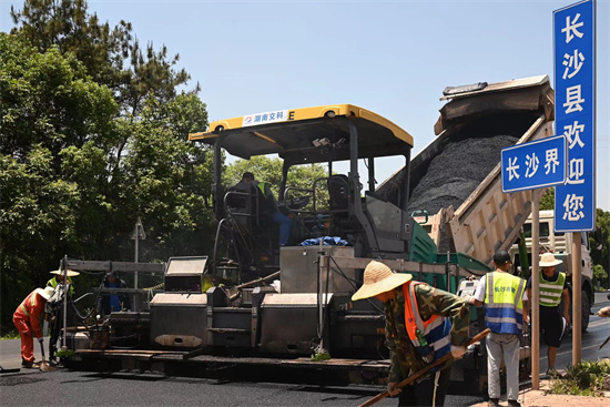 工人正在進(jìn)行“極薄磨耗層”路面的鋪筑。受訪單位供圖