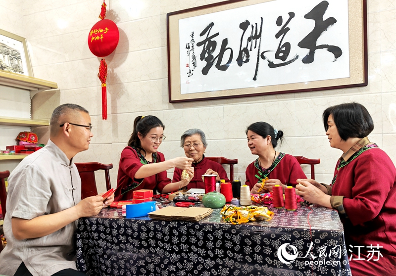 王秀英老人指導(dǎo)孫女制作香包。人民網(wǎng) 閆峰攝