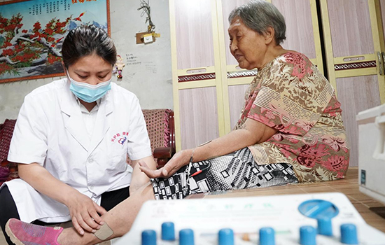 護理團隊醫(yī)生為老人進行低頻功能康復(fù)。陳佳兵攝