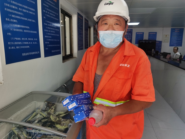 1環(huán)衛(wèi)工倪建宏小憩后，為還同事帶去冷飲。人民網(wǎng)記者王繼亮攝