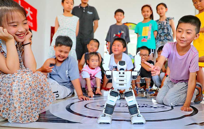 2022年7月19日，河北省秦皇島市海港區(qū)白塔嶺街道秦皇半島第二社區(qū)內(nèi)，小朋友正在觀看“機器人跳舞”。 曹建雄攝