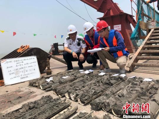 圖為勘察設(shè)計(jì)人員與海事局工作人員查看巖芯情況?！∥赫?攝