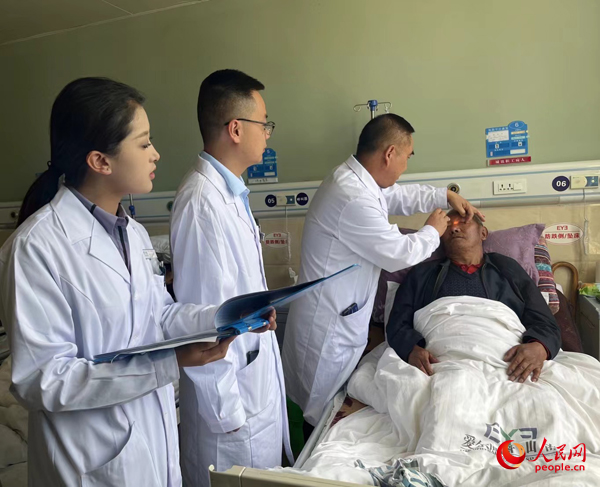 董光明（左三）帶領(lǐng)醫(yī)生對患者進(jìn)行術(shù)前檢查。人民網(wǎng)記者 杜燕飛攝